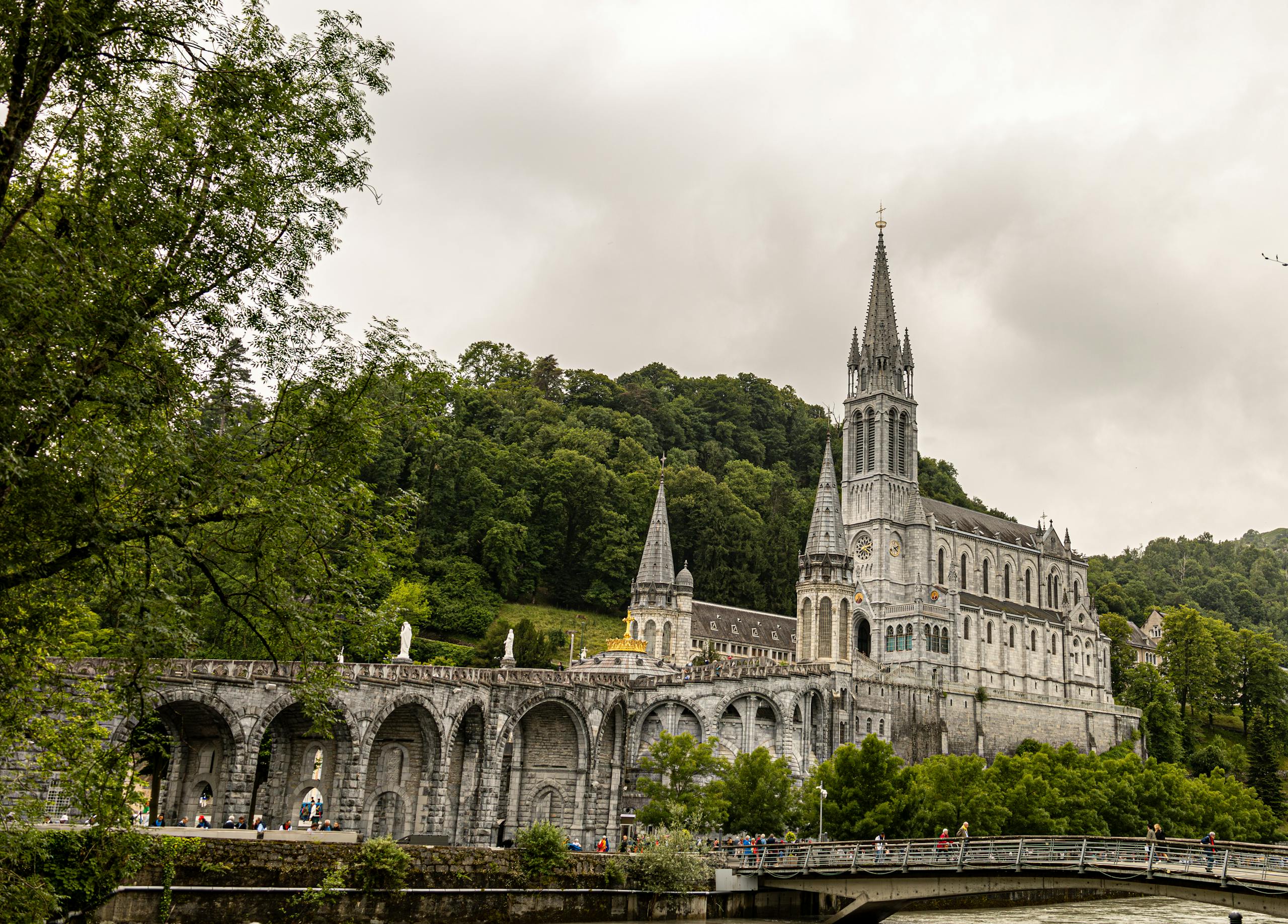 Stunning view of the Basilica of Our Lady of Lourdes against lush green landscape.